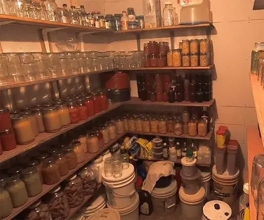 Root cellar pantry shelves filled with jars of home-canned food
